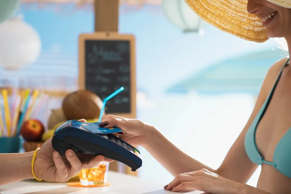 Kobieta płaci kartą na plaży